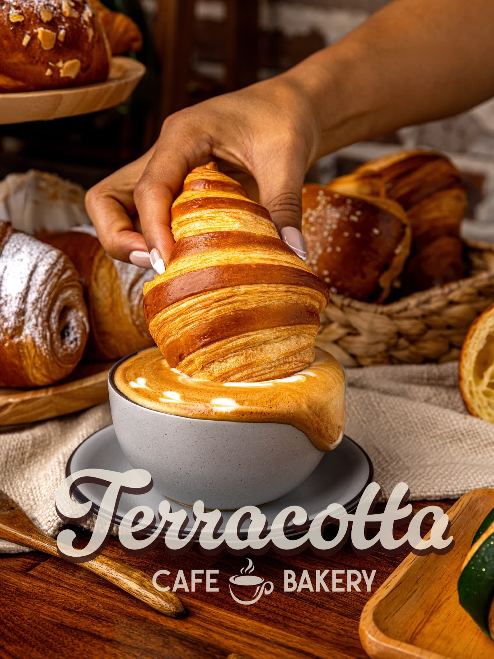 Hand dipping a flaky croissant into a cup of coffee