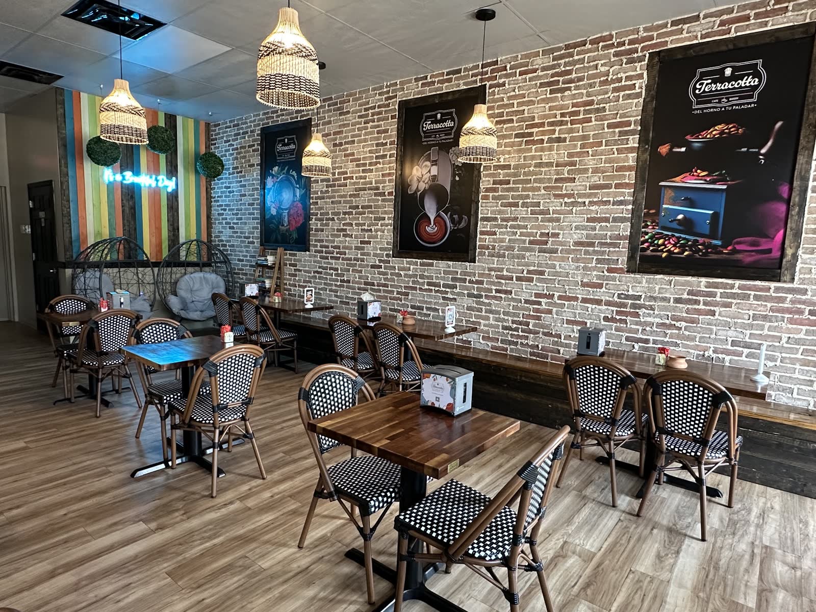 Dining room with bistro chairs, brick wall, and wicker egg chairs