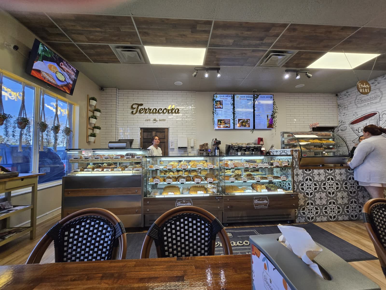 Order Here counter, pastry cases, and subway-tile wall
