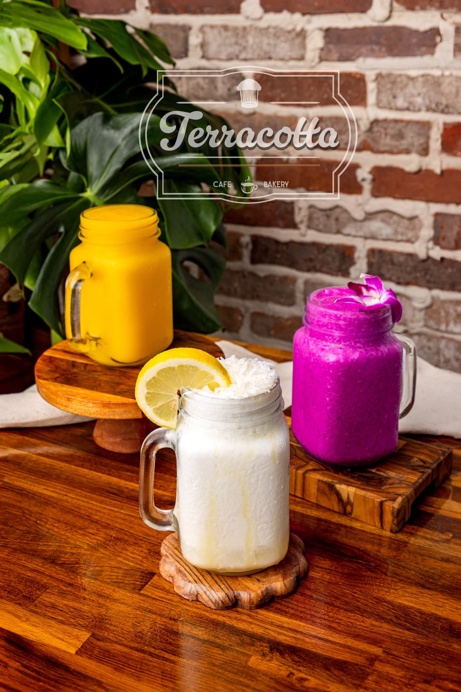 Three colorful smoothies in mason jars on a wood table